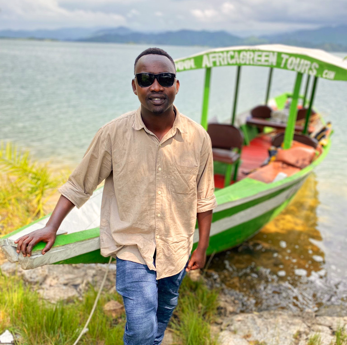Umuyobozi wa Africa Green Tours iruhande rw’ubwato ku Kiyaga cya Kivu.