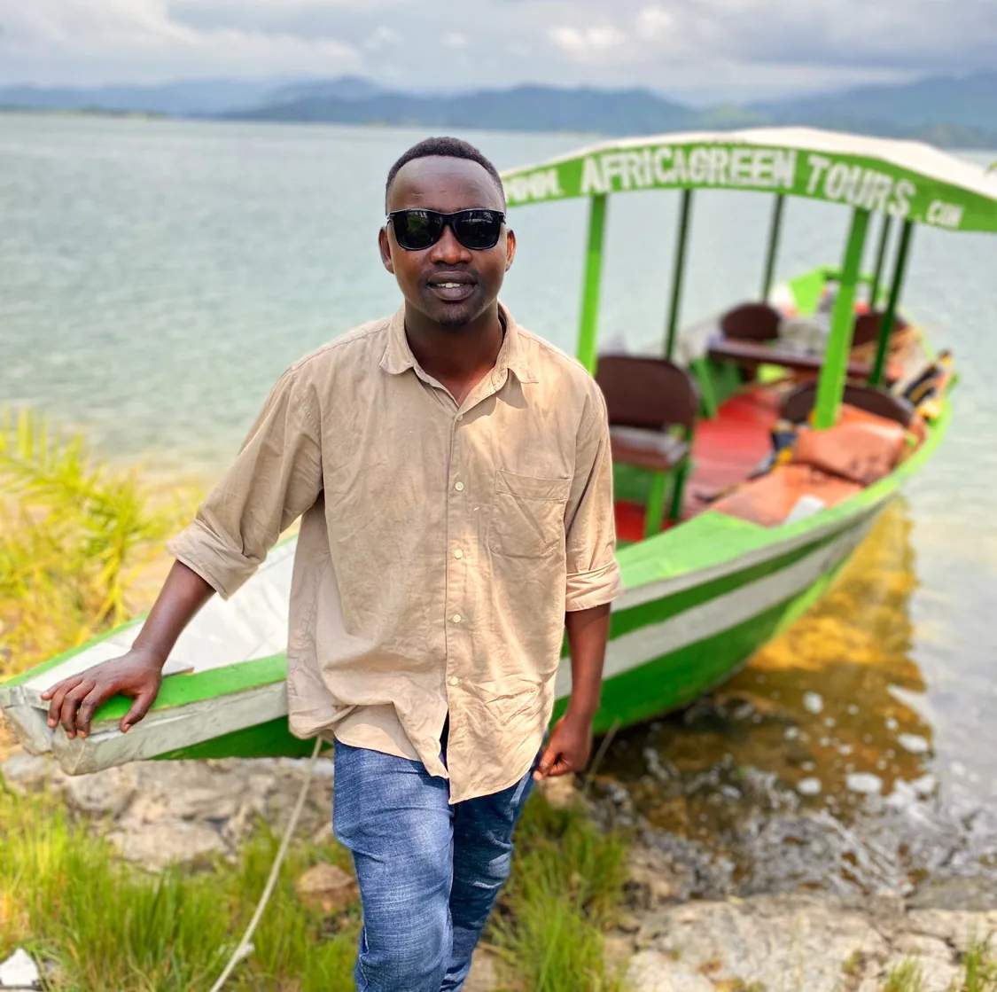 Africa Green Tours guide beside a boat on Lake Kivu.