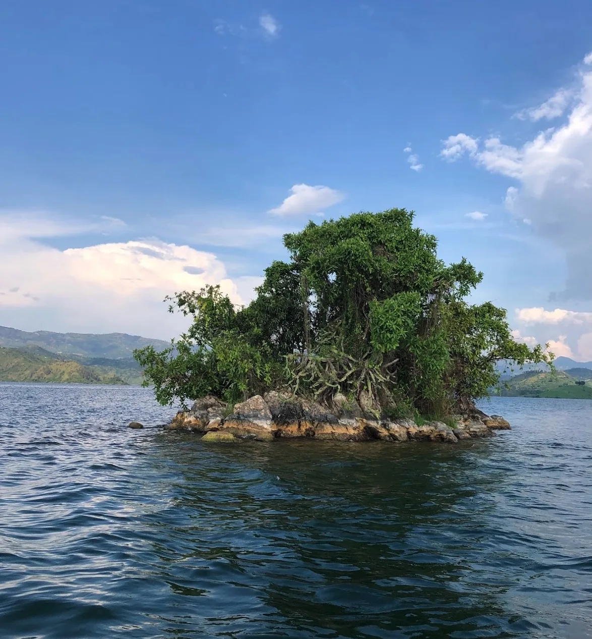 A small tree-covered island surrounded by water on Lake Kivu.