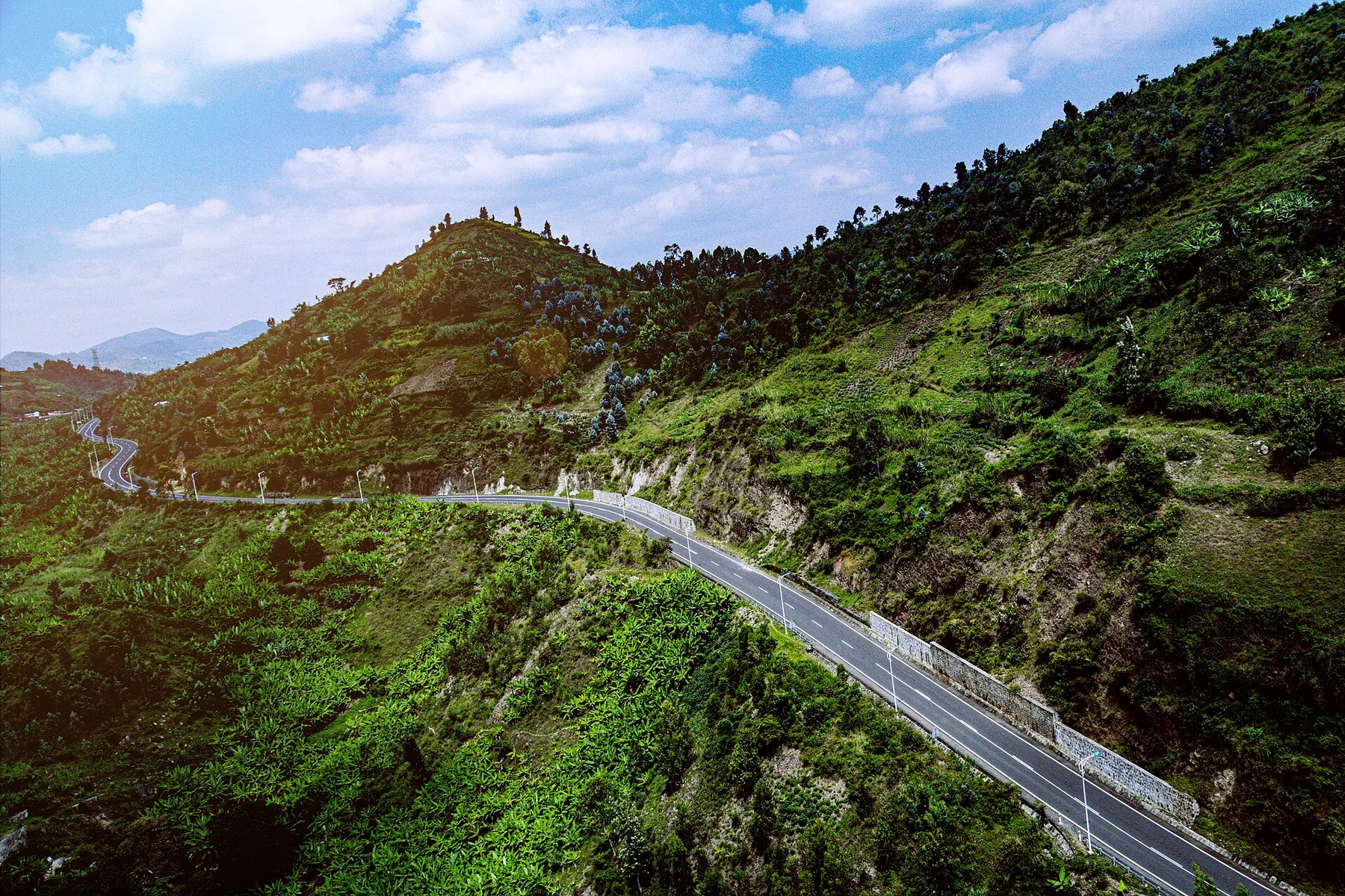 An aerial view of the Kivu Belt Road crossing the green hills of western Rwanda.